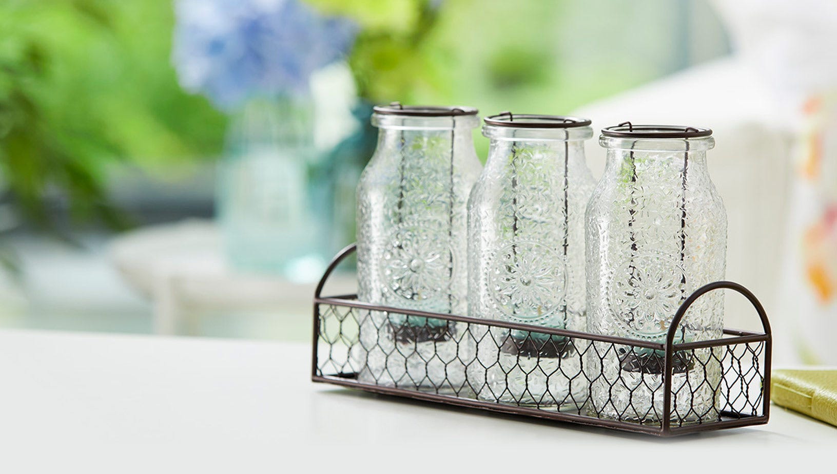 A group of three Vintage Milk Bottle Lantern Candle Holders in a basket.