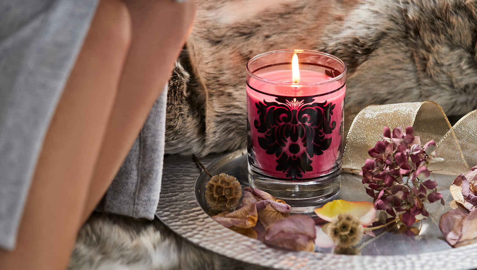 Candle Jar burning on a silver platter.